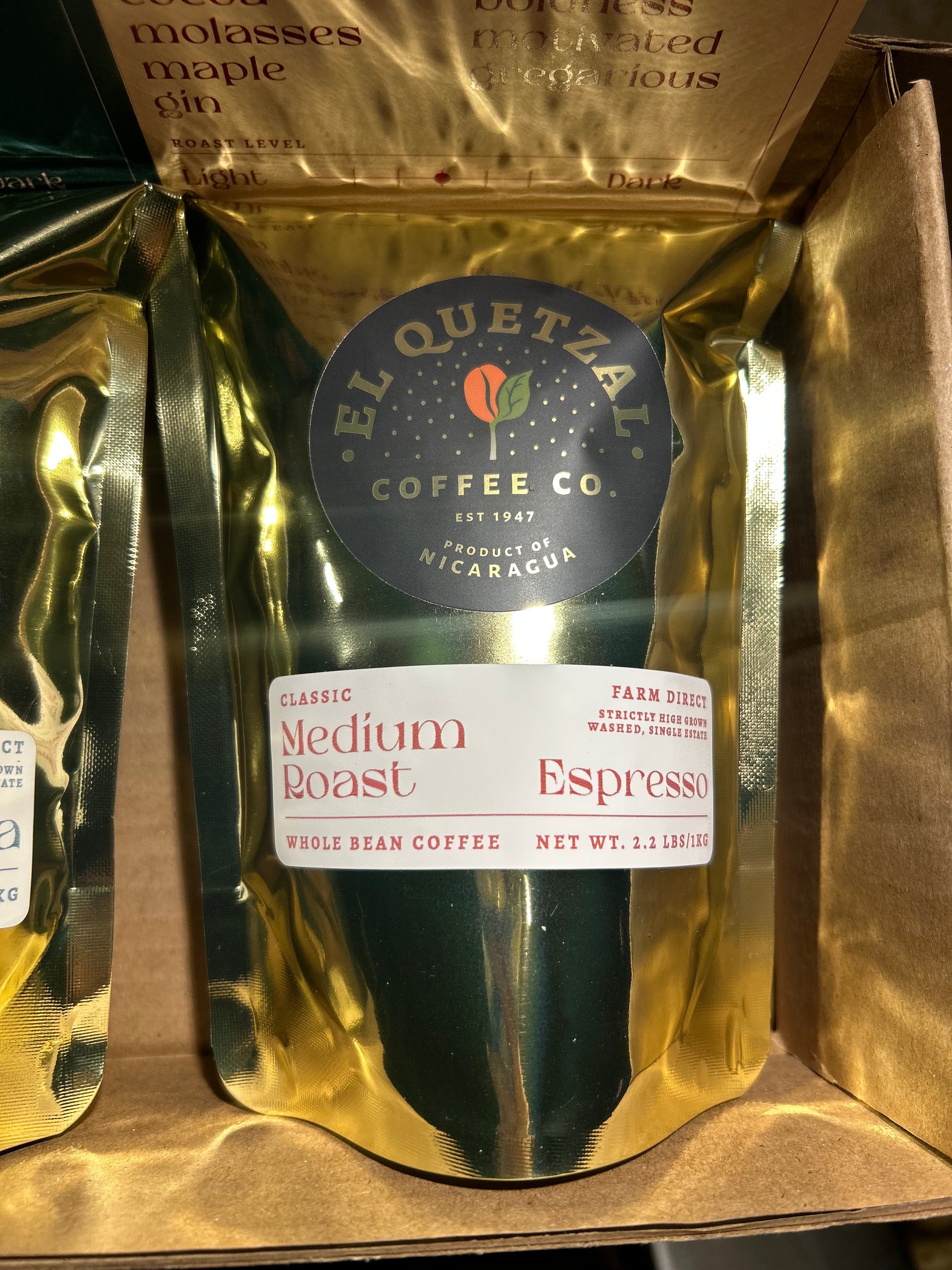 Gold coffee bag with 'El Quetzal Coffee Co' label on a brown background